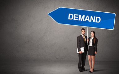 Young business person in casual holding road sign