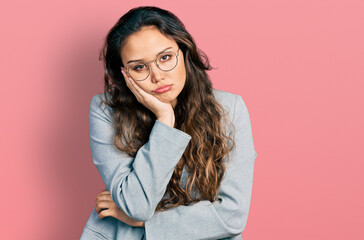 Fototapeta premium Young hispanic girl wearing business clothes and glasses thinking looking tired and bored with depression problems with crossed arms.