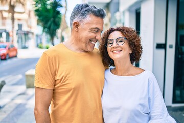 Middle age couple smiling happy standing at street of city.