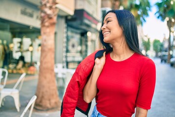 Fototapeta premium Young latin woman smiling happy walking at the city.