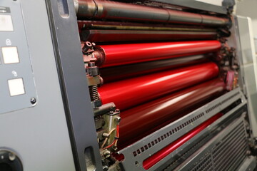 Red painted roller system of the printing machine in the printing house. Komori lithrone system....