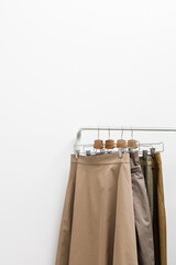 Beige clothes on a hanger on a white background