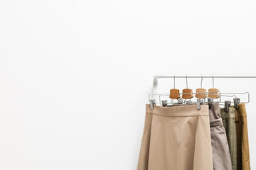 Beige clothes on a hanger on a white background