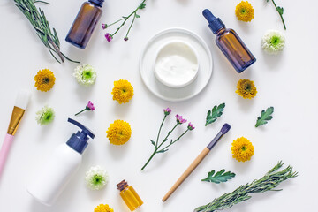 Fototapeta na wymiar Flat lay cosmetic composition, oil bottles, wellness cosmetics, herbal ingredients, flowers on a white background, top view