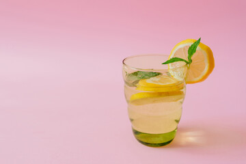 lemonade in a glass on a pink background. lemon and mint. vitamin charge, antioxidant. healthy life. fresh ingredients, diet beverage