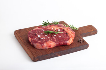 Raw rib eye steak of beef with rosemary isolated on white background
