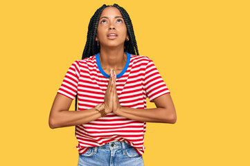 Beautiful hispanic woman wearing casual clothes begging and praying with hands together with hope...