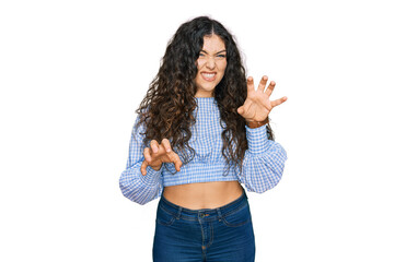 Young hispanic girl wearing casual clothes smiling funny doing claw gesture as cat, aggressive and...
