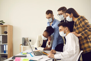 International business team wearing protective face mask to avoid covid-19 spreading having remote conversation on laptop with company staff, brainstorming on startup project in new normal office