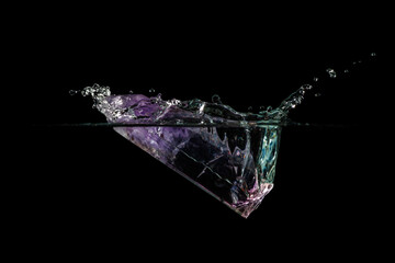 Purple quartz crystal falling into water