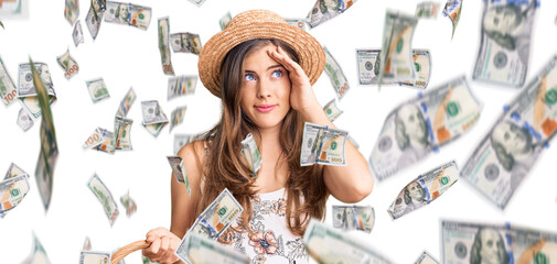 Beautiful caucasian young woman wearing summer hat and holding picnic wicker basket with bread...