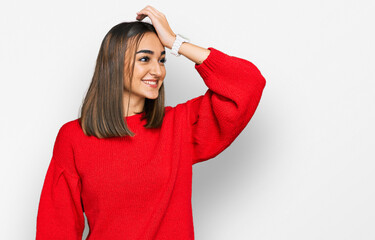 Beautiful brunette woman wearing casual winter sweater smiling confident touching hair with hand up gesture, posing attractive and fashionable