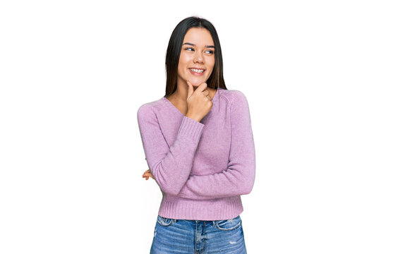 Young hispanic girl wearing casual clothes with hand on chin thinking about question, pensive expression. smiling with thoughtful face. doubt concept.