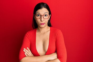 Young latin woman wearing casual clothes and glasses skeptic and nervous, disapproving expression on face with crossed arms. negative person.