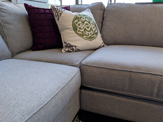 view of several pillows piled on a light colored couch in a living room