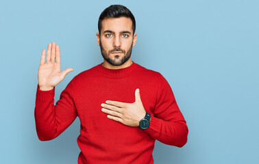 Young hispanic man wearing casual clothes swearing with hand on chest and open palm, making a...