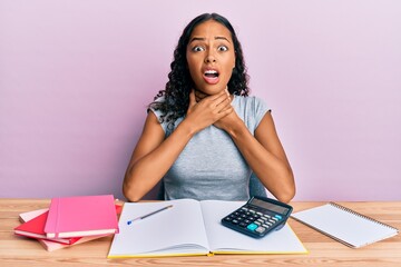 Young african american girl accountant working at the office shouting and suffocate because painful strangle. health problem. asphyxiate and suicide concept.