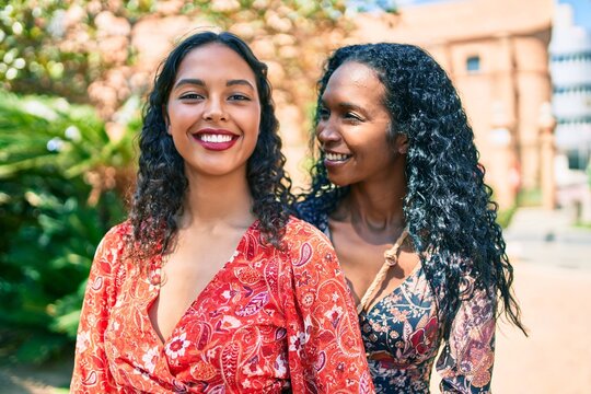 African american mother and daughter smiling happy hugging at the park.