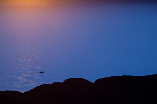 The Bolivian side of Lake Titicaca provides stunning backdrops to the setting sun after a rainstorm in the Andes.  