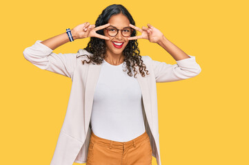 Young african american girl wearing business clothes doing peace symbol with fingers over face, smiling cheerful showing victory