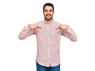 Young hispanic man wearing business shirt looking confident with smile on face, pointing oneself...