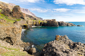 Obraz premium Blue ocean bay with green and rocky coastline and beautiful mountains, Qeqertarsuaq, Greenland