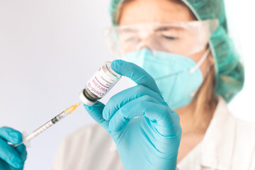 Nurse loading a syringe with Covid-19 vaccine. Pandemic concept. Selective focus.