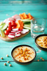 Hummus appetizer with carrot, radish, tomato and cucumber