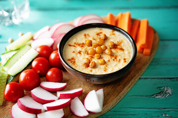 Hummus appetizer with carrot, radish, tomato and cucumber