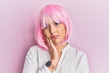 Young blonde woman wearing pink wig thinking looking tired and bored with depression problems with crossed arms.