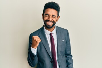 Handsome hispanic man with beard wearing business suit and tie celebrating surprised and amazed for...