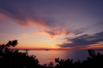Fototapeta na wymiar Beautiful seascape with an amazing sunset. Little island at far.