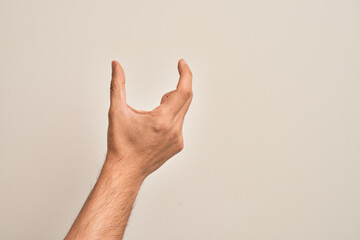 Hand of caucasian young man showing fingers over isolated white background picking and taking invisible thing, holding object with fingers showing space