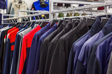 Different casual clothes hanging in the retail clothing store.