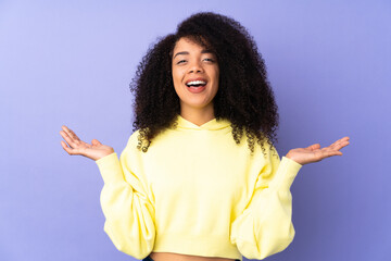 Young african american woman isolated on purple background with shocked facial expression