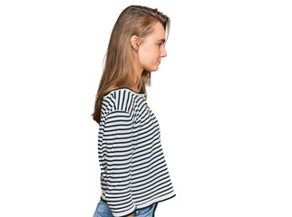 Beautiful blonde woman wearing casual clothes looking to side, relax profile pose with natural face with confident smile.