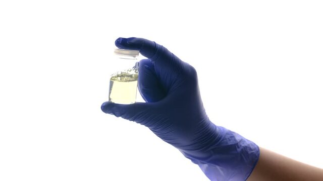 glass medical bottle with liquid in doctor laborant hands in medical blue gloves, laboratory testing of vaccine or clinic of samples for spectrophotometric analysis and experiments, medical research, 