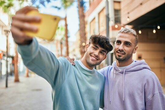 Young gay couple smiling happy making selfie by the smartphone at the city.
