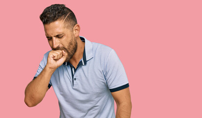 Handsome man with beard wearing casual clothes feeling unwell and coughing as symptom for cold or...