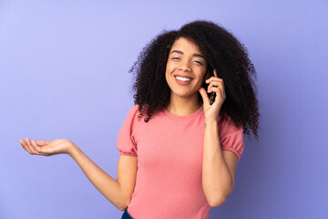 Young african american woman isolated on purple background keeping a conversation with the mobile phone with someone