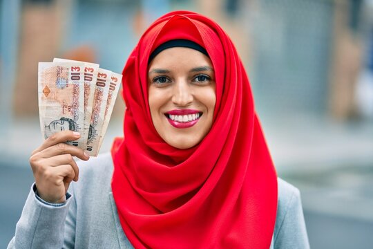 Young Arab Woman Wearing Hijab Holding Uk Pounds At The City.