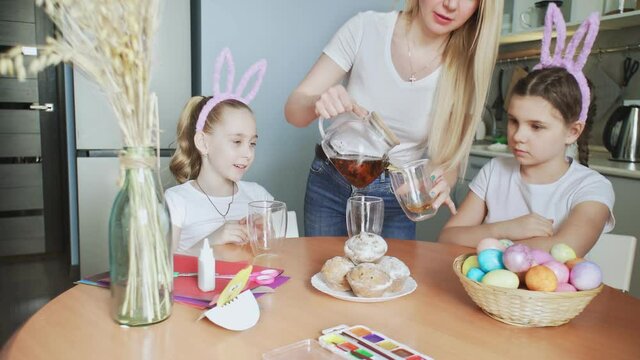 Happy Easter. Preparing the family for Easter. Woman pours tea into cups