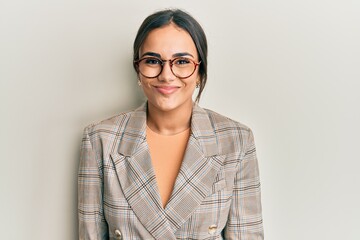 Young brunette woman wearing business jacket and glasses with a happy and cool smile on face. lucky...