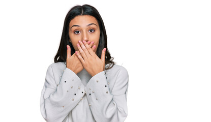 Young hispanic girl wearing casual clothes shocked covering mouth with hands for mistake. secret concept.