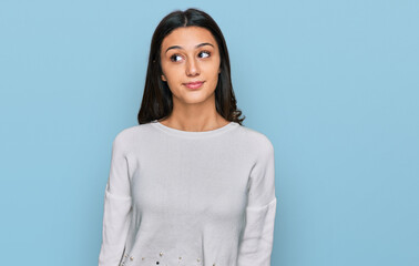Obraz premium Young hispanic girl wearing casual clothes smiling looking to the side and staring away thinking.