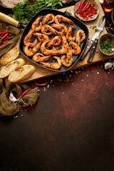 Grilled prawns in cast iron grilling pan with fresh lemon, parsley, chili, garlic white wine sauce