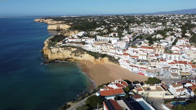 Aerial view of traditional Portuguese village by beach and cliffs, Carvoeiro, Algarve, Portugal