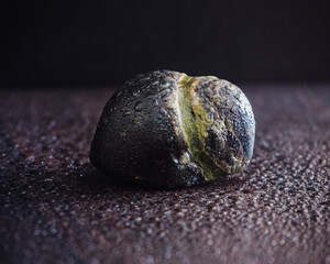 Single sea stone with water drops at the table closeup