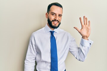 Young man with beard wearing business tie showing and pointing up with fingers number five while smiling confident and happy.