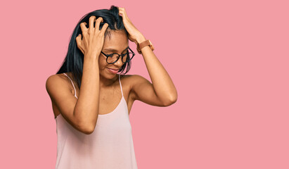 Young african american woman wearing casual clothes and glasses suffering from headache desperate and stressed because pain and migraine. hands on head.